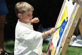 A boy paints, Lemonade Concert and Art Fair, St. Cloud State University