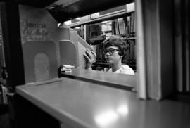 A woman shelves books at Kiehle (1952), St. Cloud State University