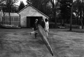 Rowing Club members move their boat out of a building, St. Cloud State University