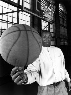 Alum Reggie Perkins spins a basketball on his finger in Eastman Hall (1930), St. Cloud State University