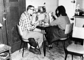 Students relax in their kitchen in the Veteran's Housing (1946) complex, St. Cloud State University