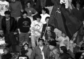 Wrestler Nikolai Volkoff walks through a crowd holding a flag from the Soviet Union before a wrestling match at Halenbeck Hall (1965), St. Cloud State University