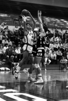 Basketball player Mike Alaspa takes a shot in a game against Gustavus Adkolphus College, St. Cloud State University
