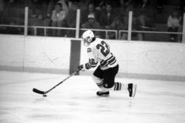 Hockey player Herm Finnegan skates with the puck in a game against Air Force