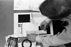 Man puts together a copy of the Chronicle in the Chronicle newsroom, St. Cloud State University