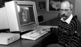 Robert Bixby sits at a computer, St. Cloud State University