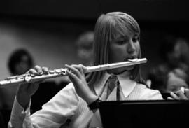 Woman plays a flute at band practice, St. Cloud State University