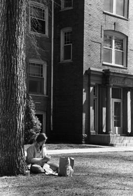 Student relaxes outside of Lawrence Hall (1905), St. Cloud State University