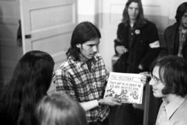 A man sells alternative newspapers at a Vietnam war protest