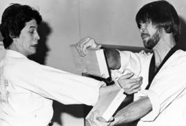 St. Cloud Traditional Tae Kwon Do Club member Wayne Robinson breaks boards held by Kevin Kastelle