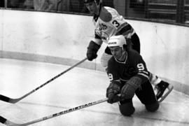 Hockey player John Fitzsimmons hits the puck during a game against the University of Wisconsin-Superior, St. Cloud State University