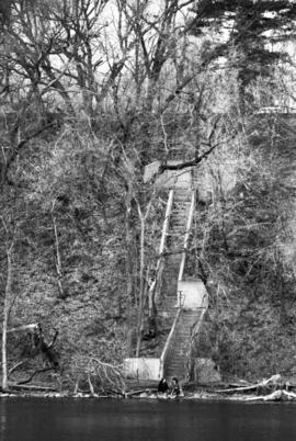 Two women sit together on the banks of the Mississippi River, St. Cloud State University