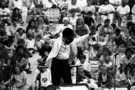 A man conducts an orchestra, Lemonade Concert and Art Fair, St. Cloud State University