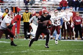 Mike McKinney runs with a football during a football game, St. Cloud State University