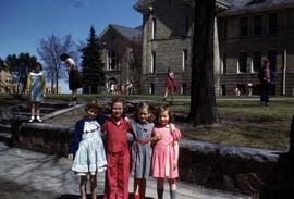 Four students stand in front of Riverview (1913), St. Cloud State