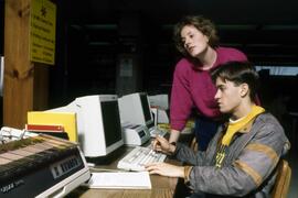 Librarian Susan Hubbs Motin helps a student in the library, St. Cloud State University