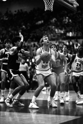 Basketball player Terry Kuechle taking a shot in a game against the University of North Dakota, St. Cloud State University