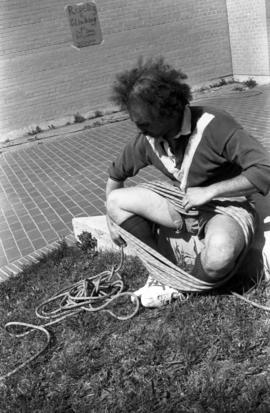 Joel Dhien wraps up robe after climbing an Atwood Memorial Center (1966) wall, St. Cloud State University