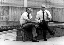 Two men sit outside, St. Cloud State University