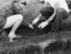 Two students excavate ground, St. Cloud State University