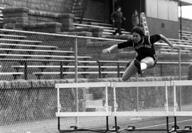 Sue Wahl jumps hurdles during a track meet, St. Cloud State University