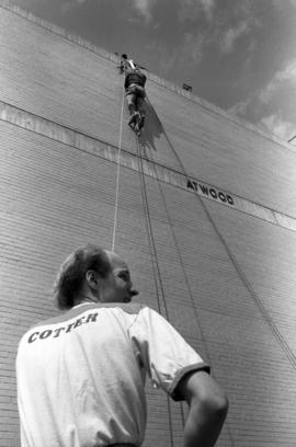 Joel Lindmeer climbs an Atwood Memorial Center (1966) wall, while Al Cottingham looks on, St. Cloud State University