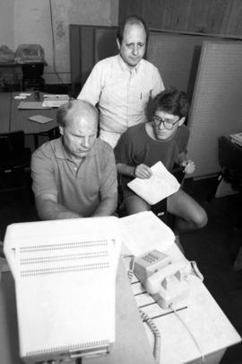 Dave Wogen, Stephen Frank, and a student work together on a computer, St. Cloud State University