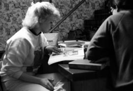 A woman searches through a book, KVSC trivia weekend, St. Cloud State University