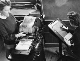 Eleanor Niemi (standing), Betty Bensen (seated) make copies, St. Cloud State University