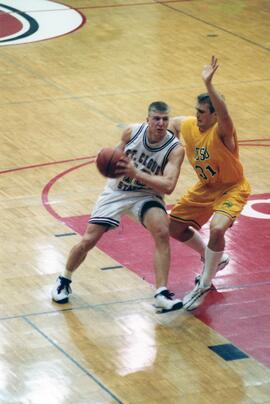 Jason Kron runs with a basketball during a game, St. Cloud State University