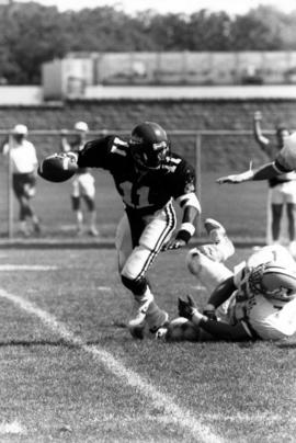 Football player Stacy Jameson avoids a tackler, St. Cloud State University