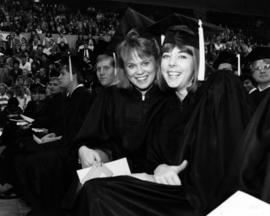 Marcy Haben and Sara Grachek sit together at commencement, St. Cloud State University