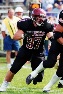 Football player Jeremy Pilarski runs on a football field, St. Cloud State University