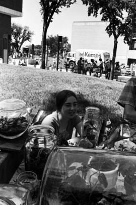 A woman sits near her merchandise, Lemonade Concert and Art Fair, St. Cloud State University