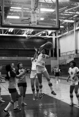 St. Cloud State University basketball player Sue Wahl grabs a rebound during a game with Dr. Martin Luther College