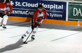 Hockey player Alison Ribar shoots a puck during a game, St. Cloud State University