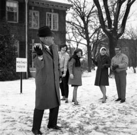 President Robert Wick playfully throws snow at students in front of Whitney House (1956), St. Cloud State University