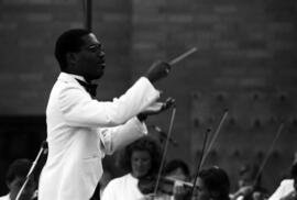 Man conducts an orchestra, Lemonade Concert and Art Fair, St. Cloud State University