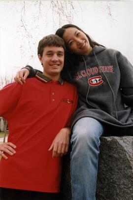 Man and a woman stand and sit together, St. Cloud State University