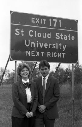 Vanguard student group members Shirley Thoennes and John Verkennes II stand by new signs directing I-94 freeway motorists to St. Cloud State University