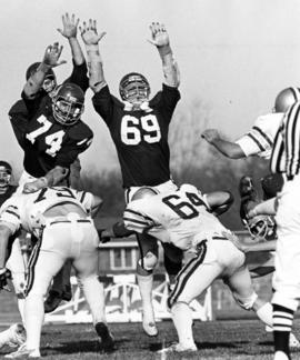 St. Cloud State University football members Tim Whitesell and Bruce Hagberg attempt to block a kick in a game against Bemidji State University