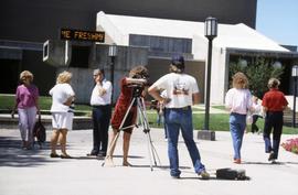 Two students use video camera near Atwood Memorial Center (1966), St. Cloud State University