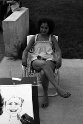 Woman sits for a caricature, Lemonade Concert and Art Fair, St. Cloud State University