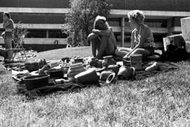 Two women sit on the lawn with their pottery, Lemonade Concert and Art Fair, St. Cloud State University