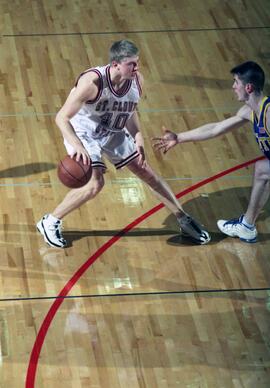 Jason Kron dribbles a basketball during a basketball game, St. Cloud State University