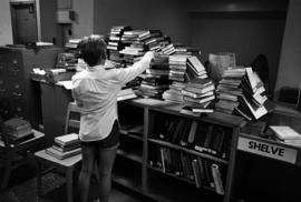 Woman organizes returned books, Kiehle Library (1952), St. Cloud State University
