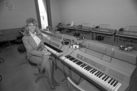 Dani Aufderhar sits at a piano, St. Cloud State University