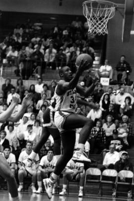 Basketball player Tony King drives to the basketball hoop during a game, St. Cloud State University