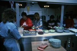 Students scoop up food in kitchen, Alnwick Castle, St. Cloud State University