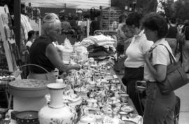 A vendor shows her wares to customers, Lemonade Concert and Art Fair, St. Cloud State University